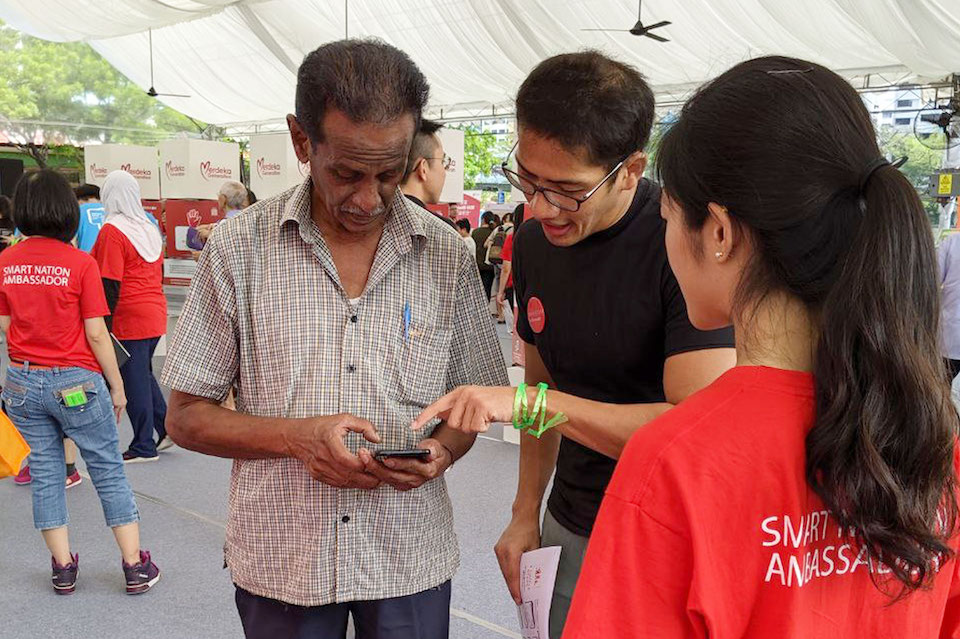 banner-image-Two volunteers are teaching a senior smartphone functionality at a roadshow